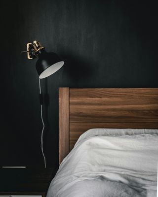 Black bedroom wall with bed
