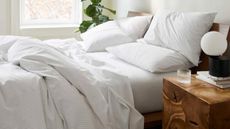 how often should bed sheets be washed: Brooklinen bedding white on bed with bedside table