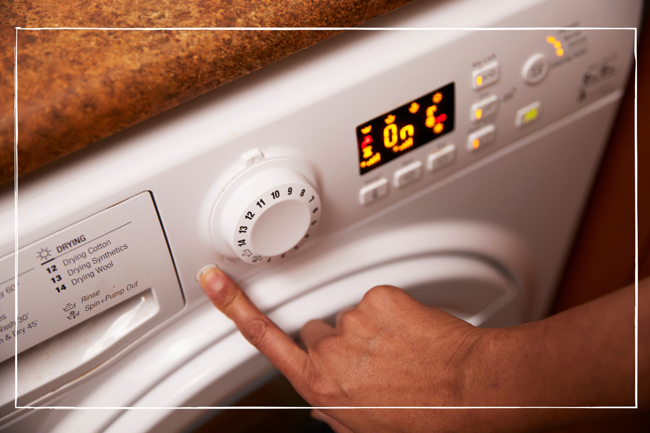 close up of a hand turning on a washing machine