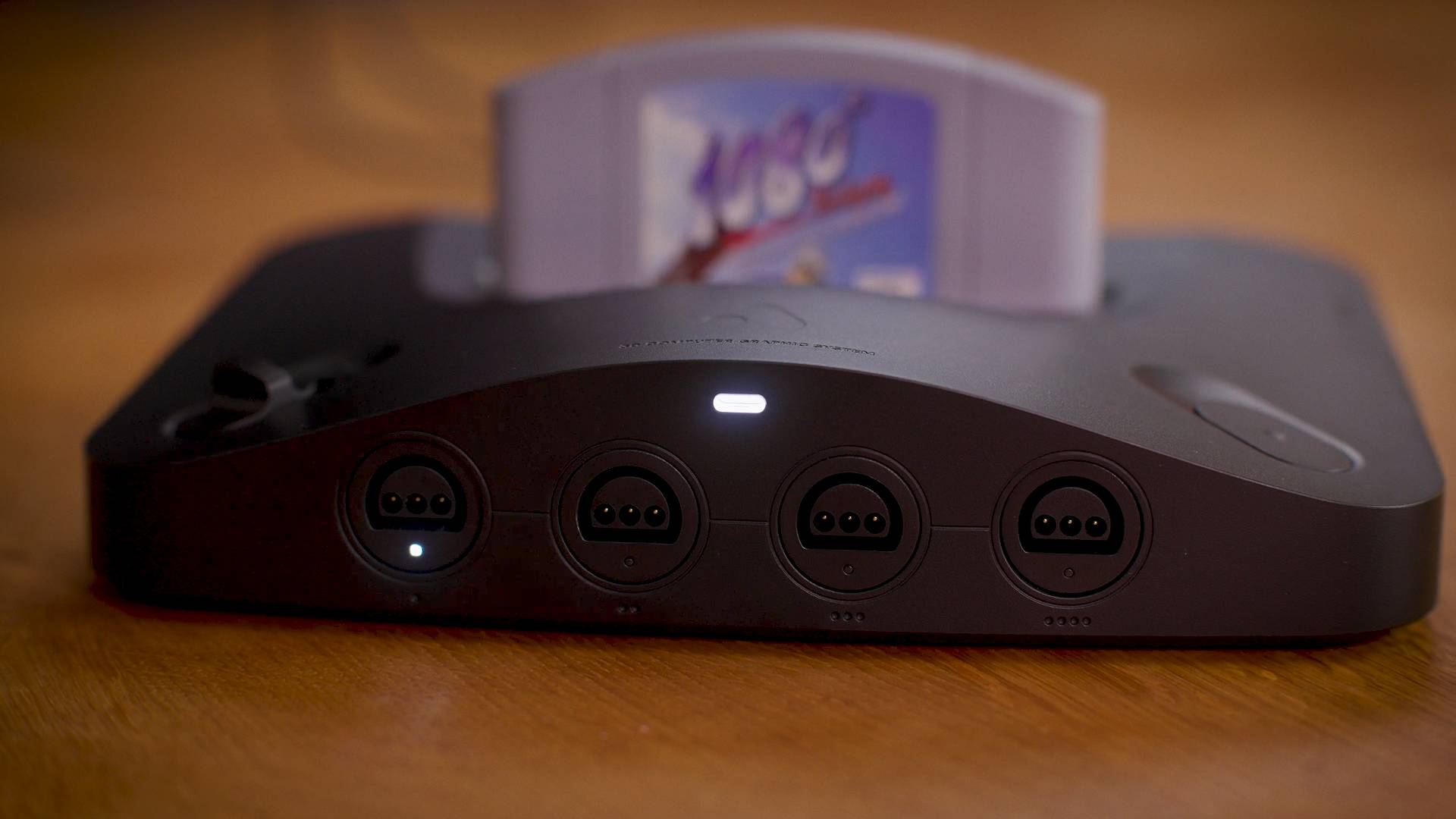 Analogue 3D console on wood surface with 1080 Snowboarding cartridge inserted.
