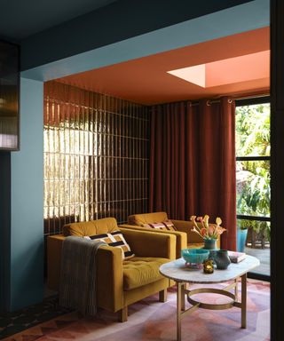 living room with mustard armchairs, red ceiling, blue-gray walls and tiled walls