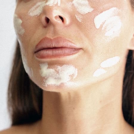An image of a woman with cream on her skin.