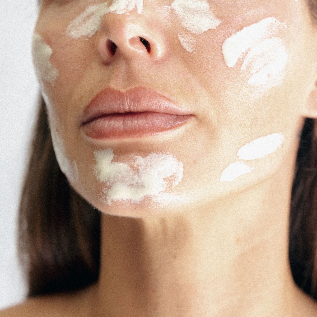 An image of a woman with cream on her skin.