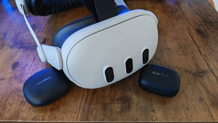 A Meta Quest 3 headset next to two pairs of wireless earbuds