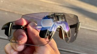 The ENGO 2 AR glasses held in hand close to the camera, with the sensors and holographic display visible, as well as ENGO and ActiveLook logos.