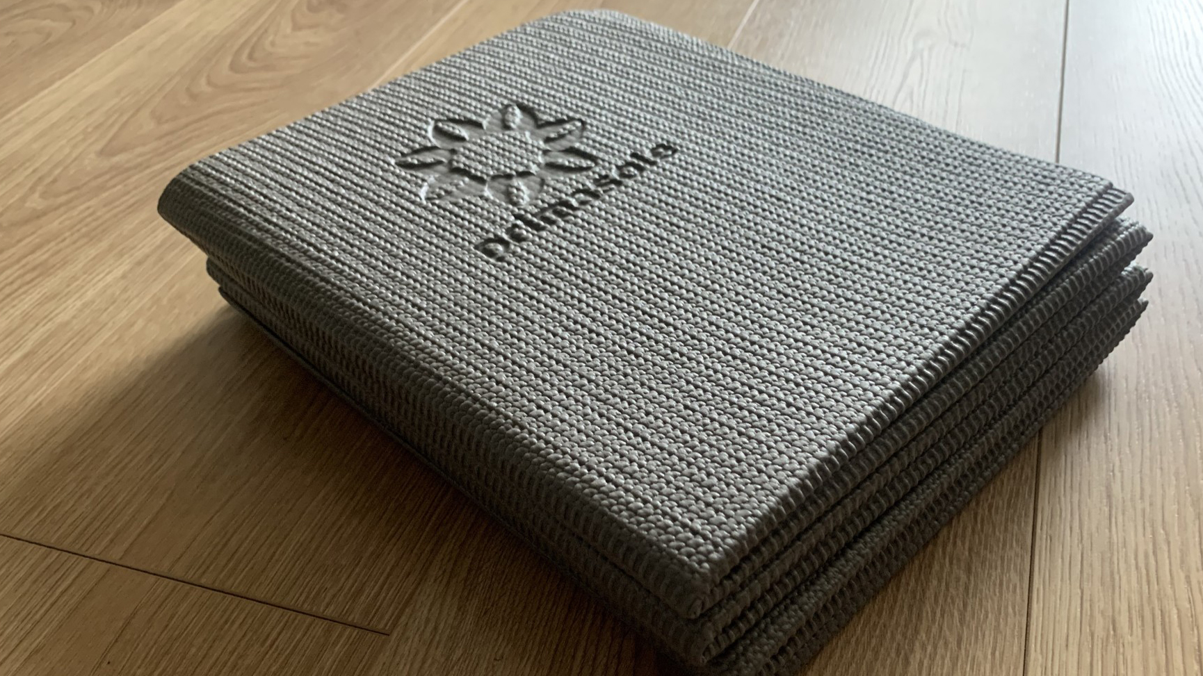 Primasole folding yoga mat on wooden floor