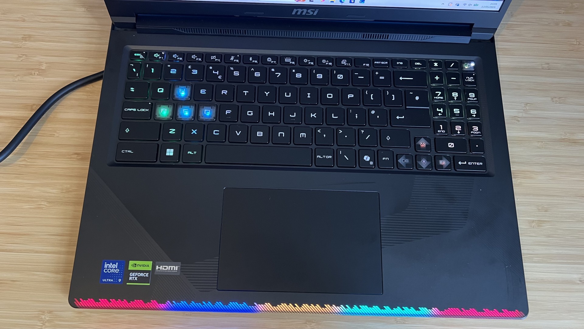 Top down view of MSI Raider 16 Max keyboard and trackpad on a wooden desk