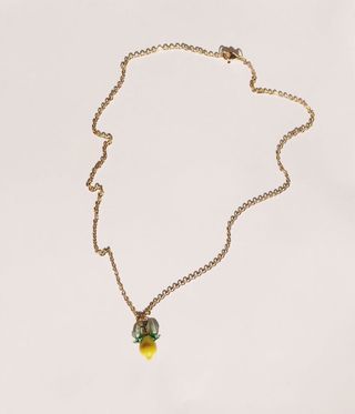 Gold chain with a yellow lemon pendant