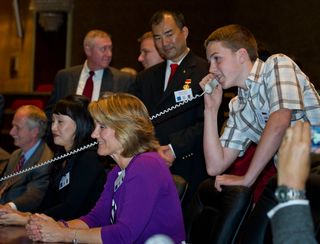 Kenny Fossum, right, youngest son of Expedition 28 NASA astronaut Mike Fossum, is seen at Russian Mission Control in Korolev, Russia speaking to his father shortly after his arrival at the International Space Station on Friday, June 10, 2011. Fossum's wife Melanie, just left of Kenny, smiles nearby.