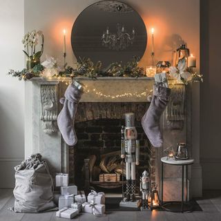 Marble fireplace with grey stockings and fairly lights