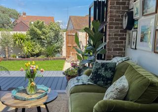 living room with green sofa, bifold doors and brick wall