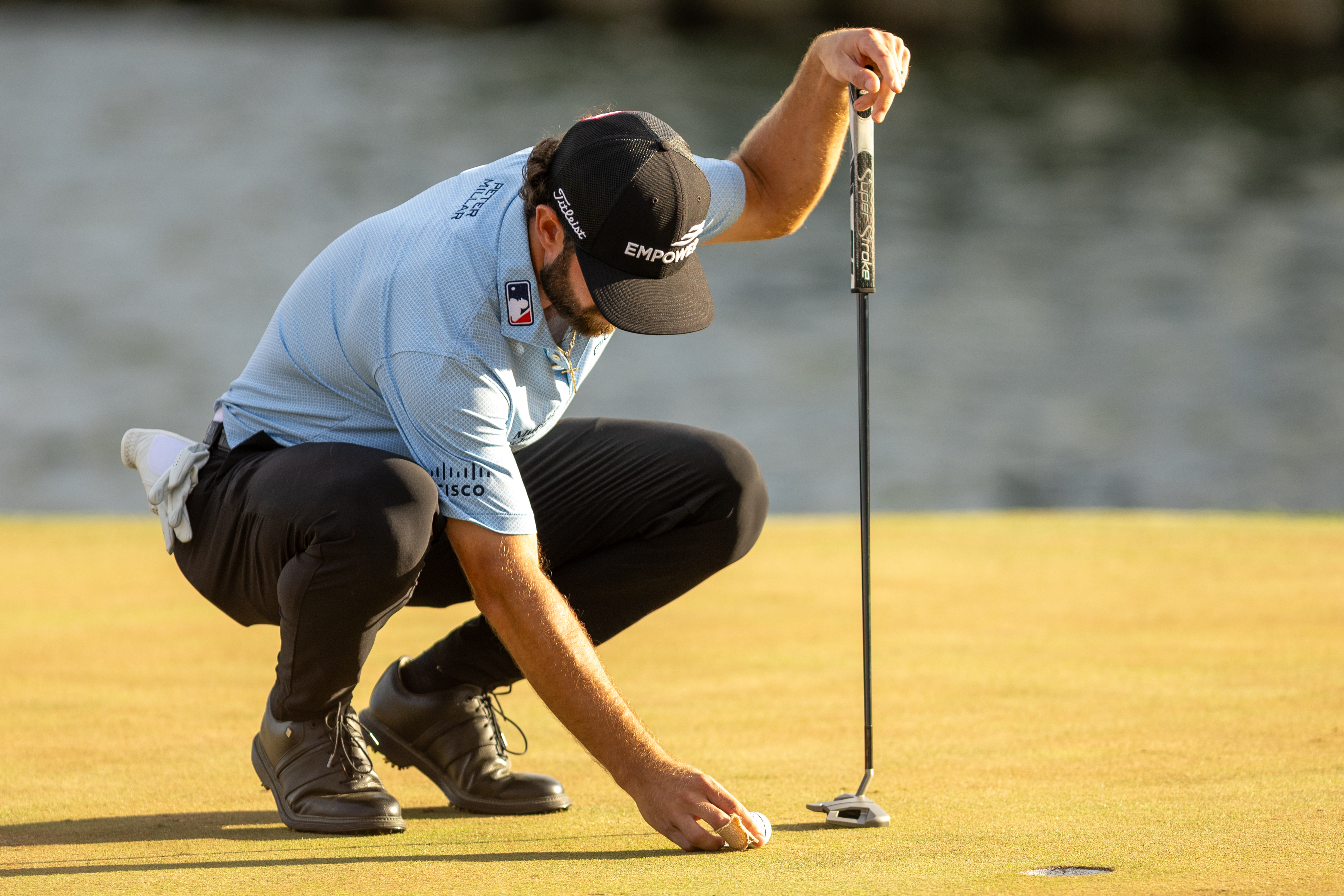 Cameron Young on the green lining up a putt