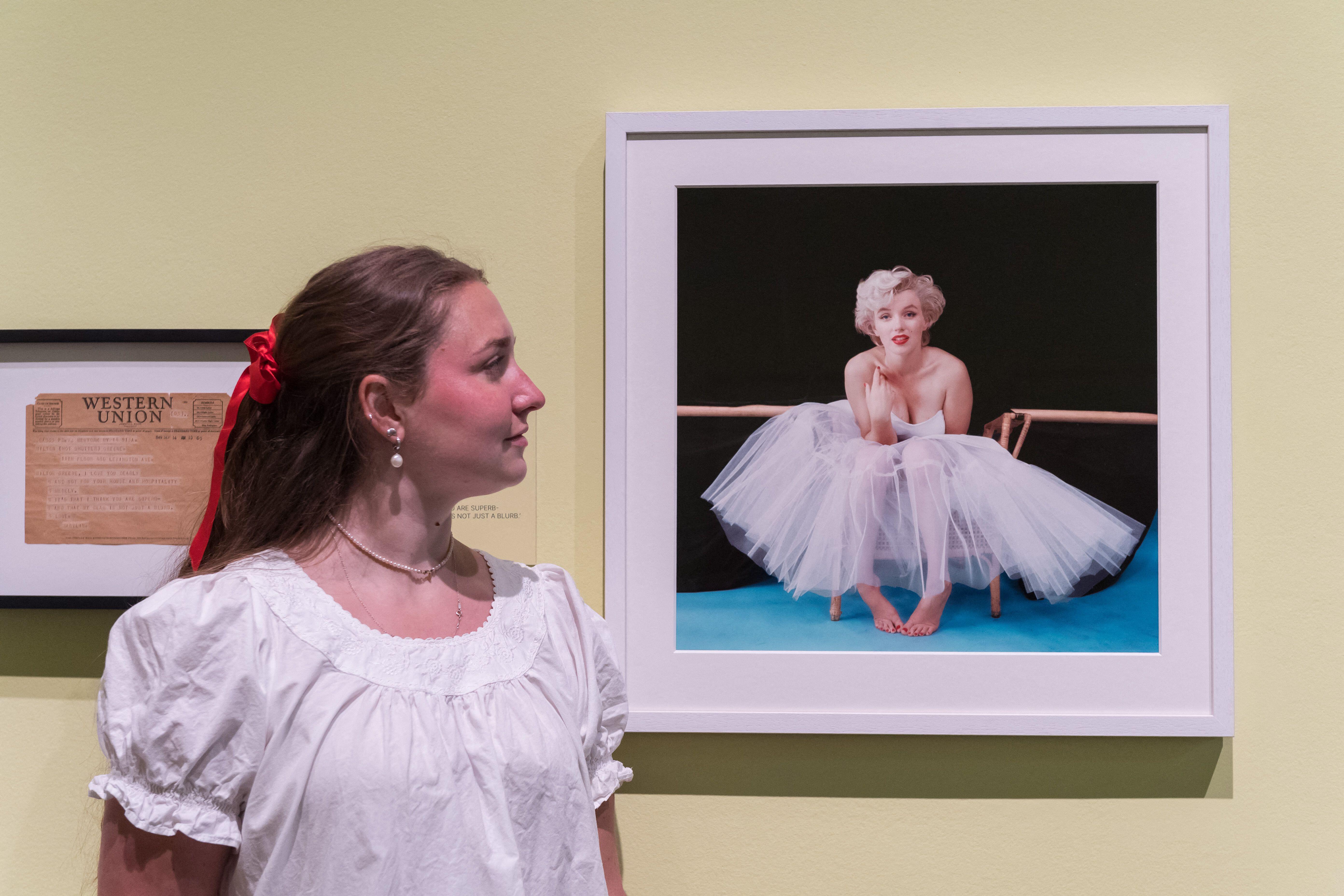 A gallery staff member looks at 'Marilyn Monroe, Ballerina Sitting', 1954, by Milton H. Greene during a photocall for Marilyn Monroe: A Portrait exhibition
