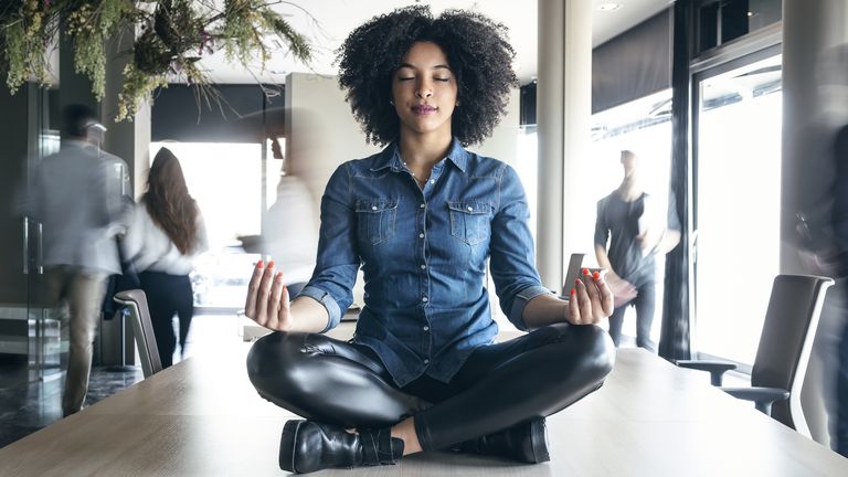 Woman meditating on an office table