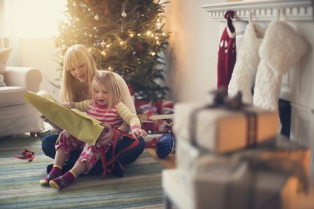 a mum and daughter unwrapping Christmas presents