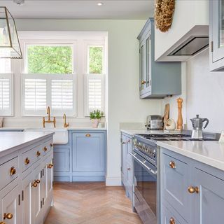 kitchen area with blue cabinet and white window