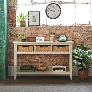 room with brick wall white wooden desk with drawers and wooden flooring