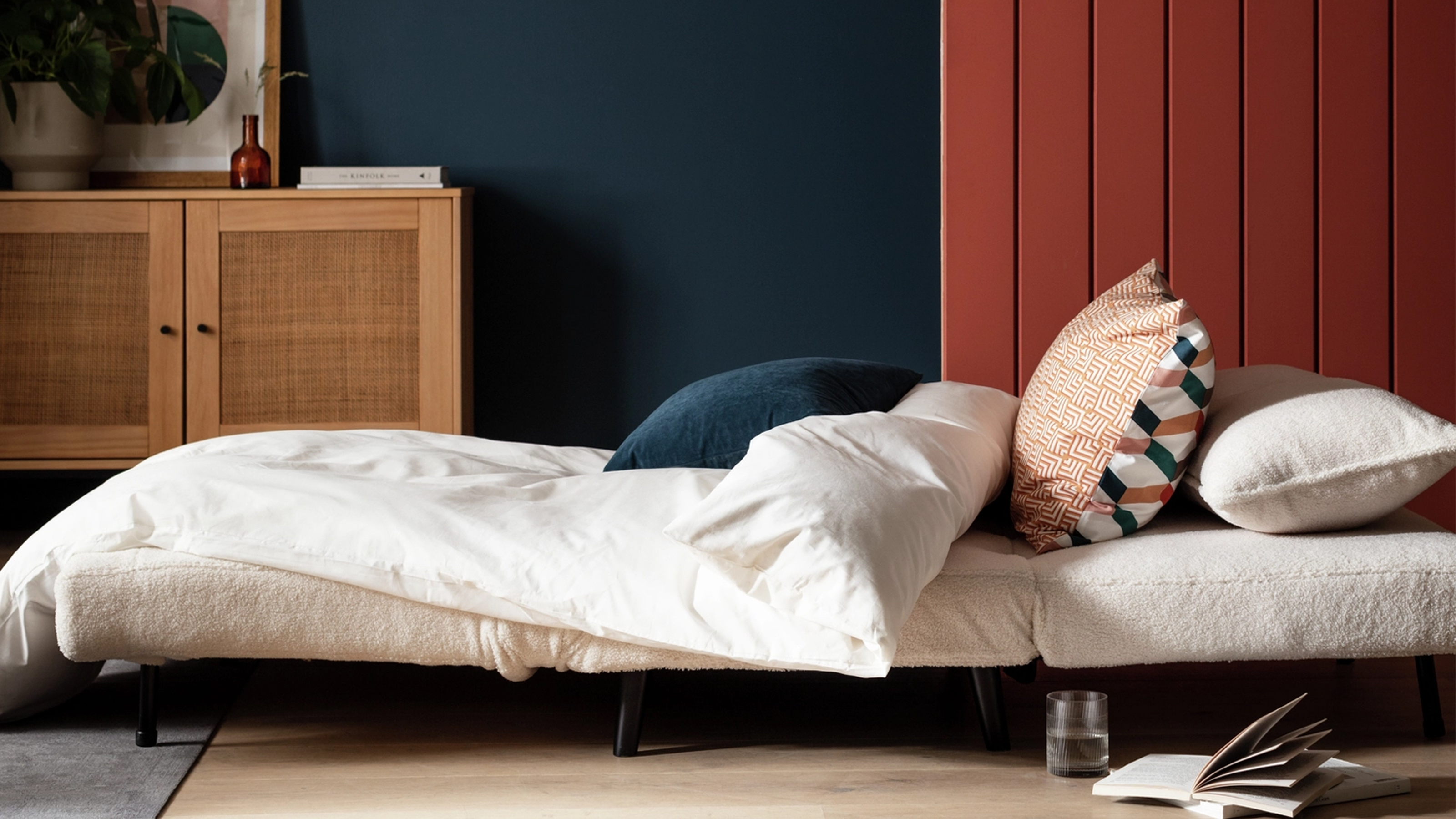 Habitat Roma Sofa Bed in cream against a blue and navy wall