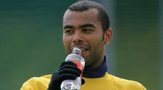 London, UNITED KINGDOM: Arsenal defender Ashley Cole sips water after a practice session at the clubs training compound in north London, 18 April 2006 ahead of their first leg semi-final match against Spanish side Villarreal 19 April. AFP PHOTO / ODD ANDERSEN (Photo credit should read ODD ANDERSEN/AFP via Getty Images)