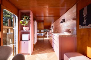 the interior of a converted cabin with a pink marble kitchen