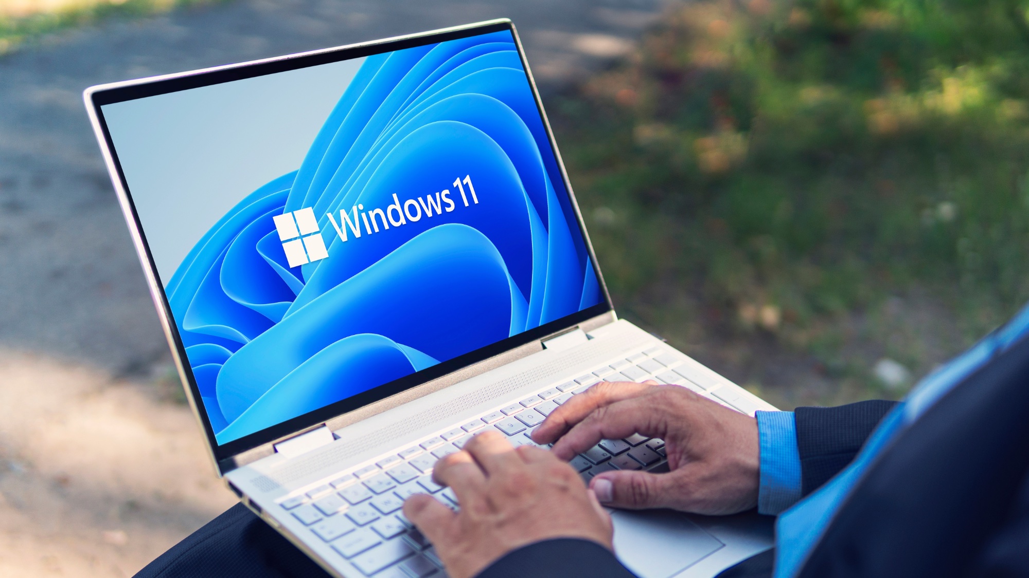 Mann tippt auf einem Windows 11-Laptop