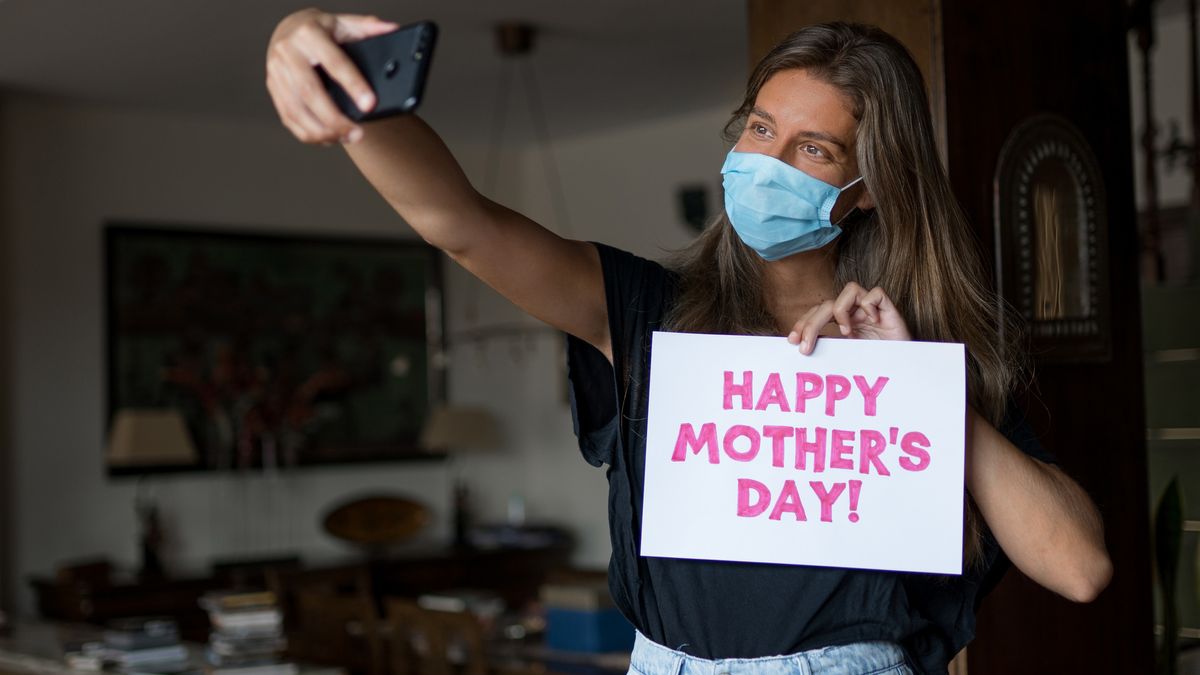 Girl wearing a mask is taking a selfie for mother&#039;s day during COVID-19.