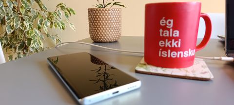 A white-backed Infinix Zero Ultra sitting on a table in front of a red coffee mug and a pot plant