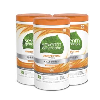 Three white and orange tubs of disinfectant wipes with a green leaf logo that says 'seventh generation' on them