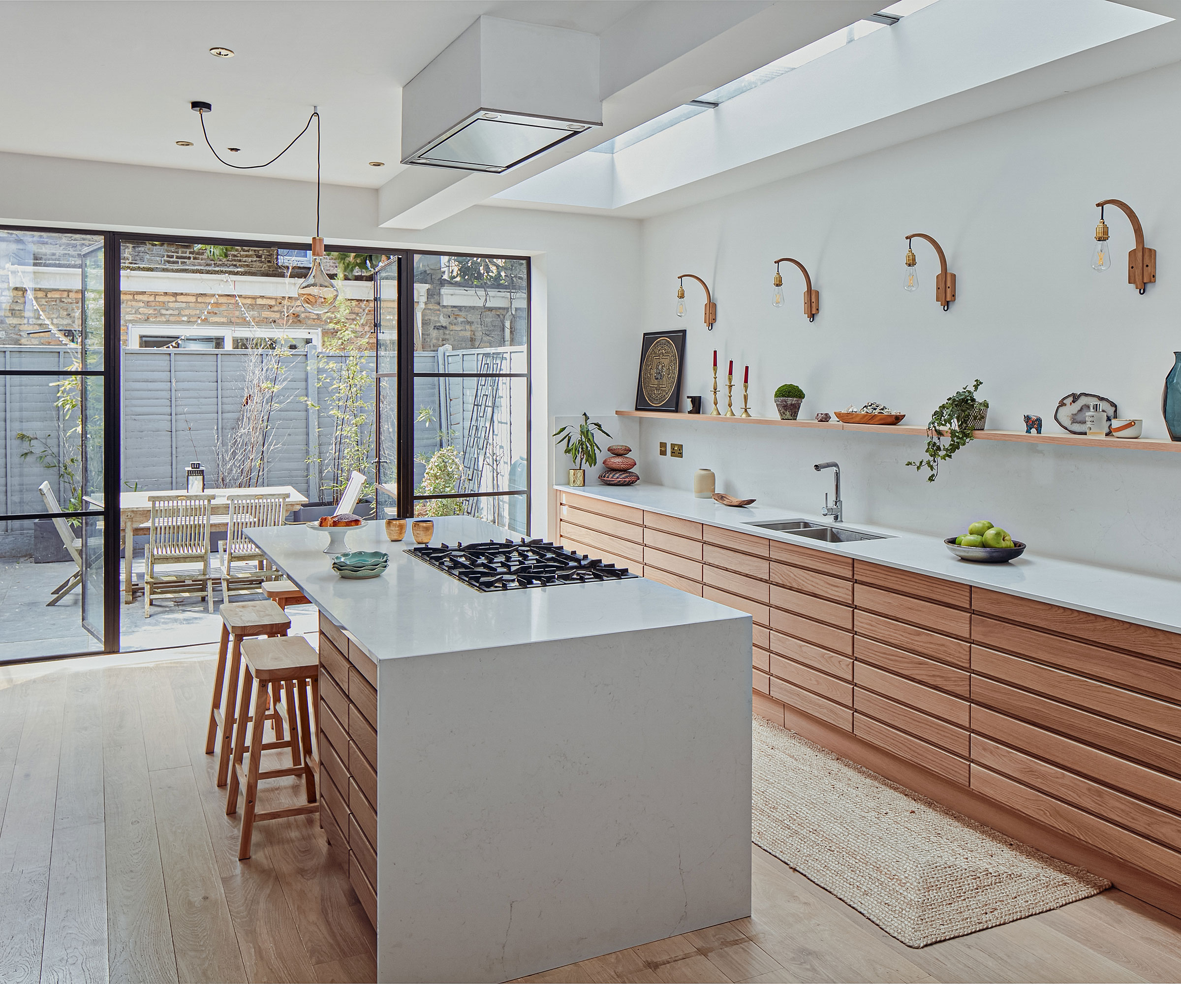 modern wooden kitchen with wooden floor and waterfall worktops over kitchen island