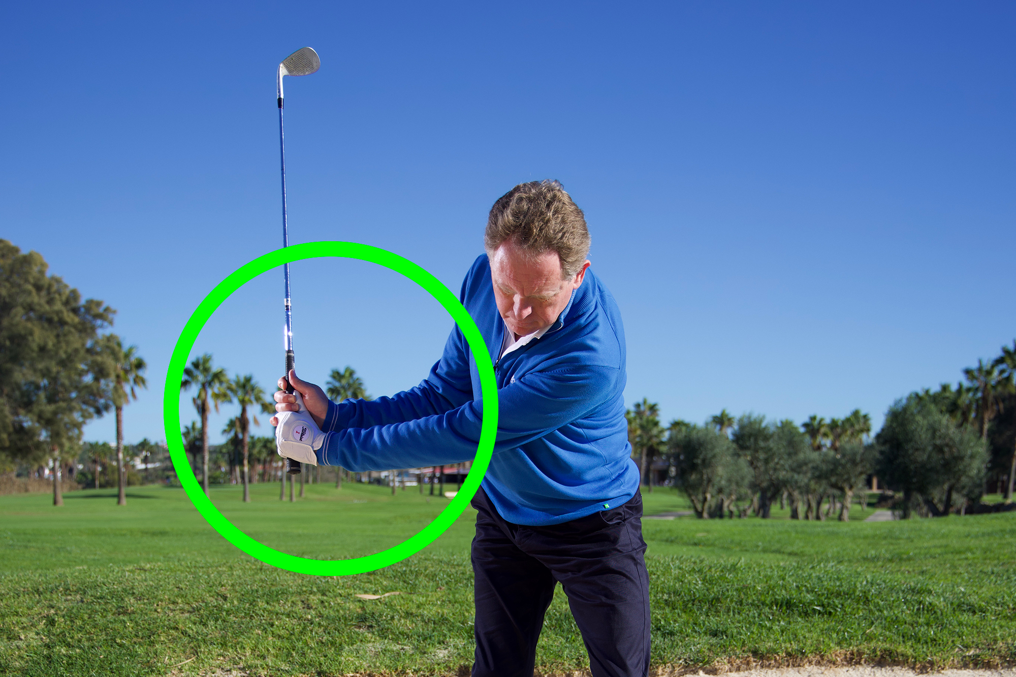 Top 50 Coach Keith Wood demonstrating the correct wrist hinge in the backswing to generate more spin out of bunkers, with a green circle to indicate the point of importance
