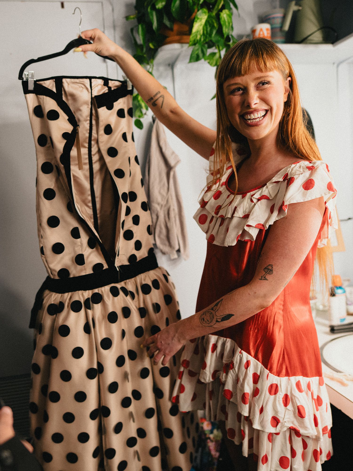 Designer Twiggy Moore holds up Gracie Lawrence's 2025 Tony Awards look, a strapless polka dot gown.