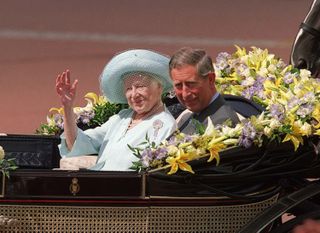 Prince Charles sits next to the Queen Mother as she waves to admirers on the occassion of her 100th birthday celebration August 4