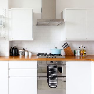 Kitchen with white cabinets and metro tiles