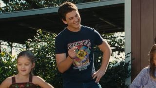 Miles Teller dances with a smile on his face in Footloose,