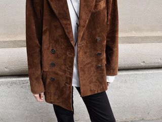 Woman wearing a brown suede blazer.