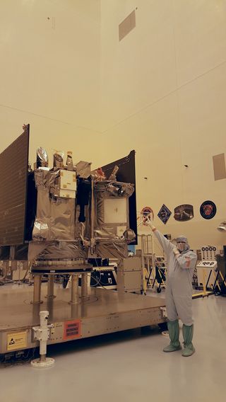 Rich Kuhns, OSIRIS-REx program manager for Lockheed Martin, points to the TAGSAM, a robotic arm that will gather a sample of the asteroid Bennu.