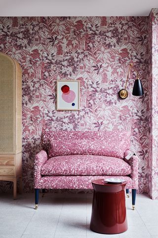 pink upholstered sofa with abstract pink wallpaper