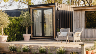 Converted shipping container with patio doors and a decking area in front of it