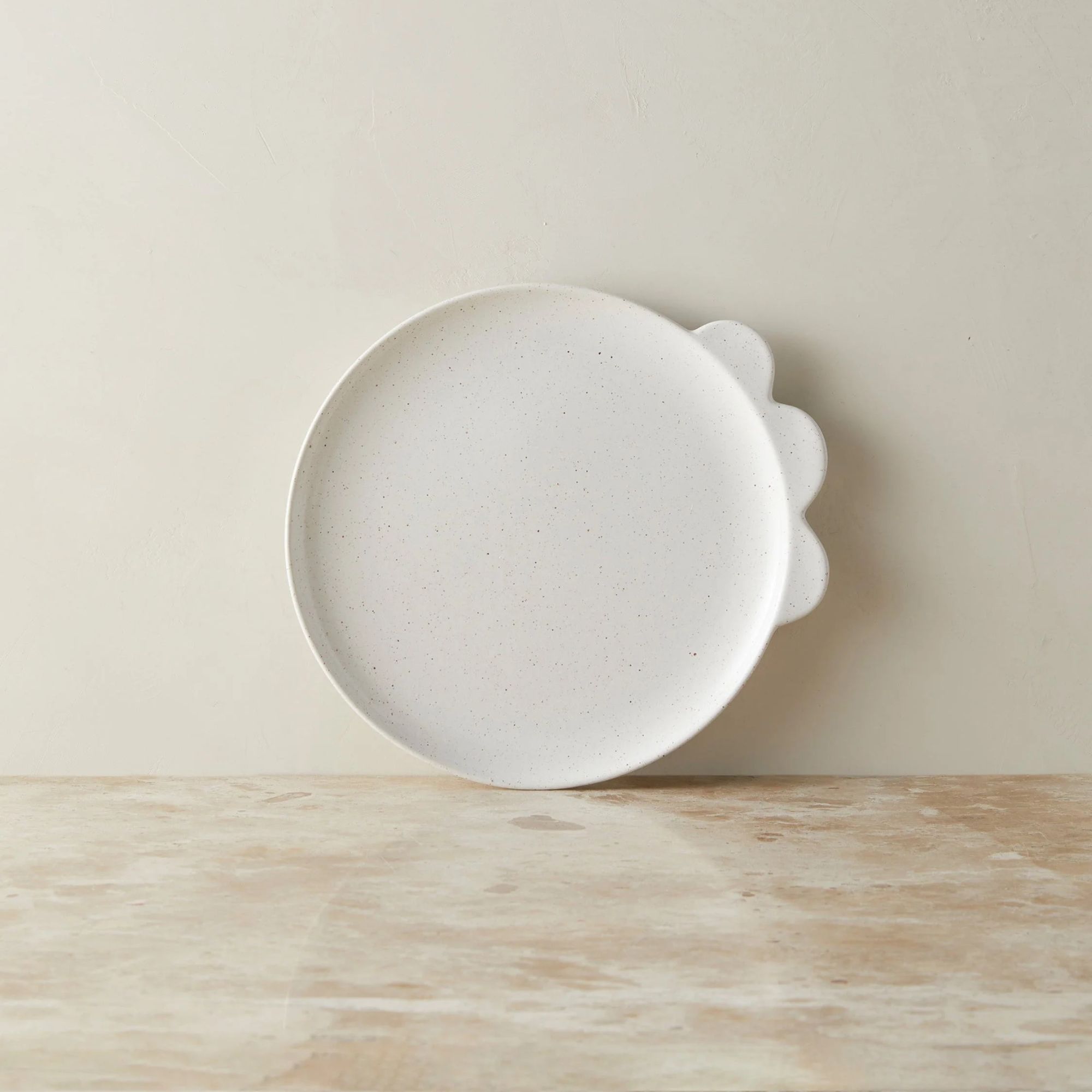 Ceramic dinner plate with three scalloped accents on the rim