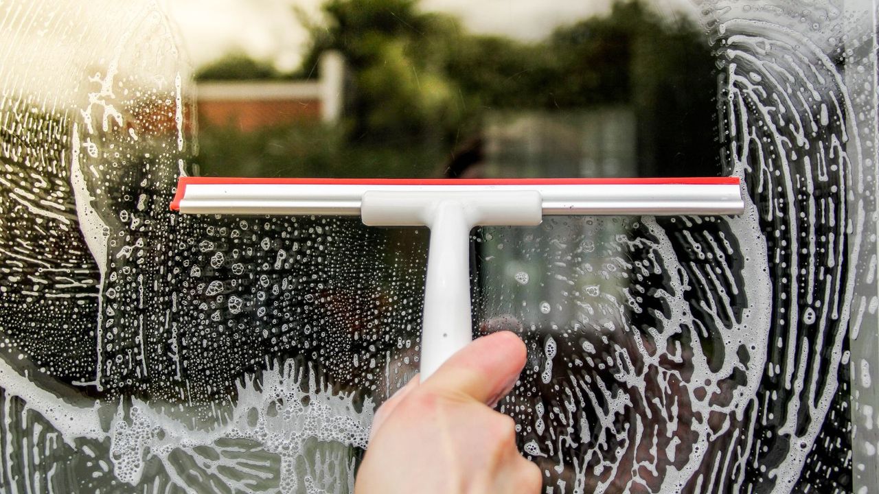 Cleaning a window with a squeegee 