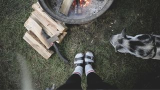 Above view of a campfire with feet wearing socks and sandals