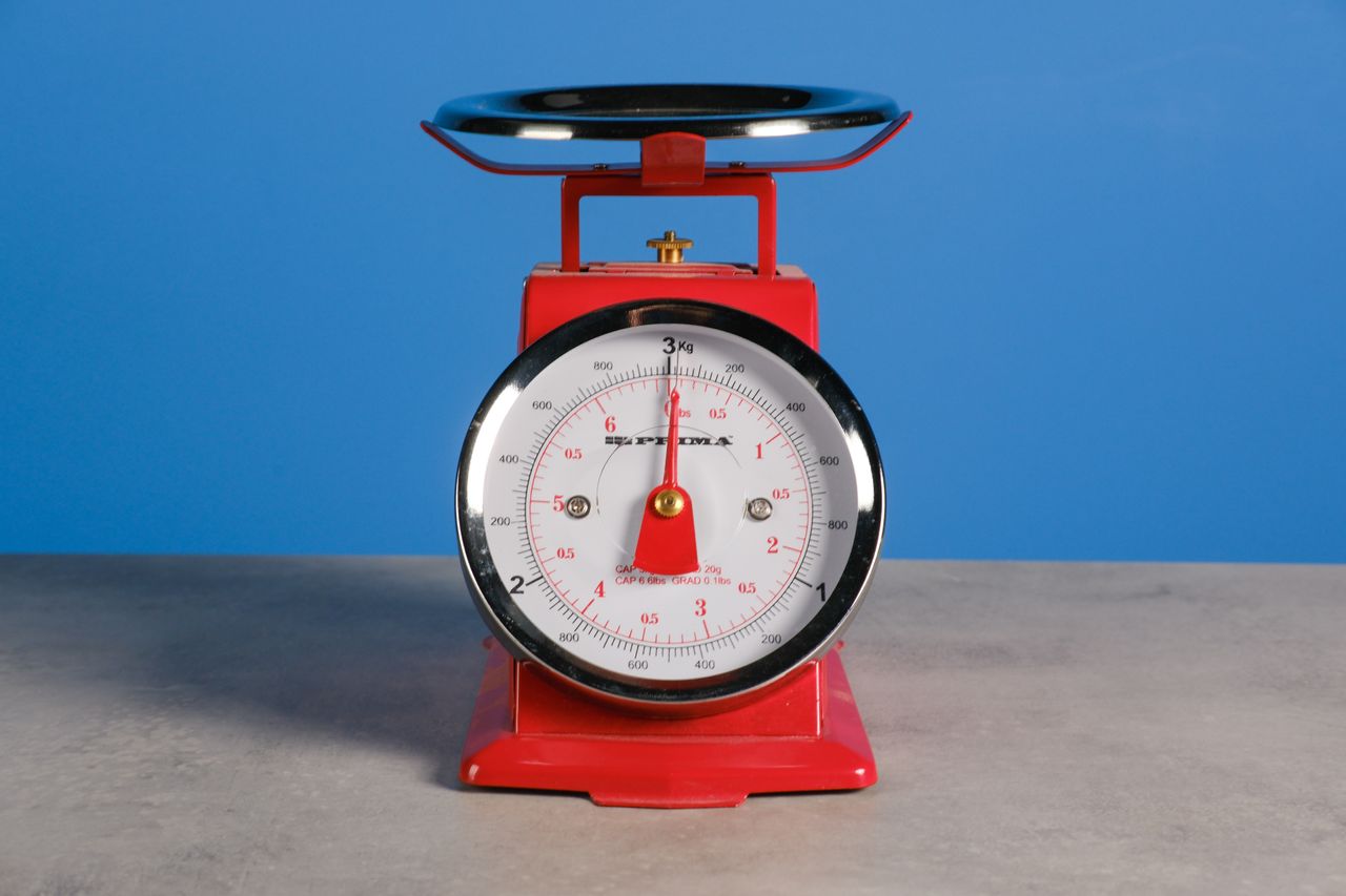 A red set of scales against a blue background