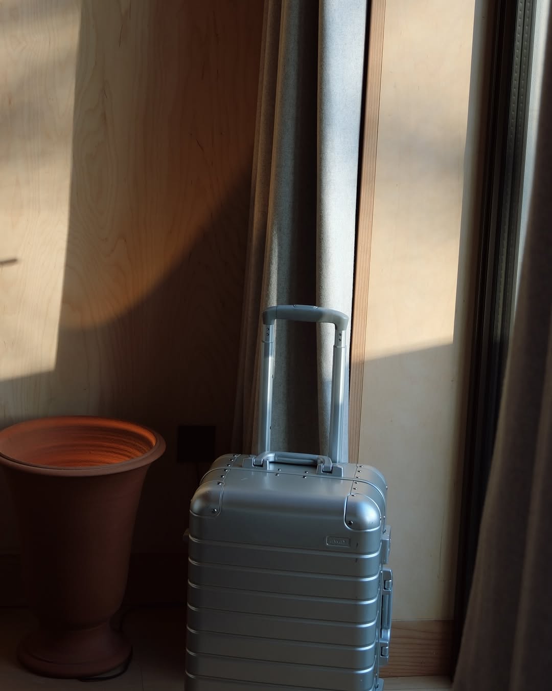 A silver suitcase in a hotel room