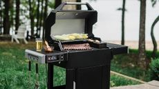 A lifestyle image of the Masterbuilt AutoIgnite Series 545 with food on the grill