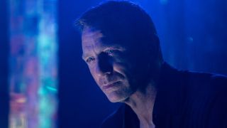 Daniel Craig looking weary in a colorful club in No Time To Die.