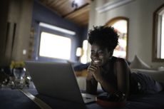 Best broadband provider: woman using laptop on bed