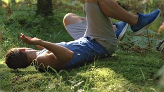 Trail runner falling down in woodland