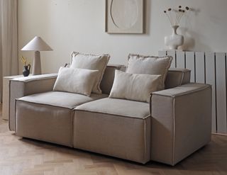 a beige sofa dressed with throw pillows