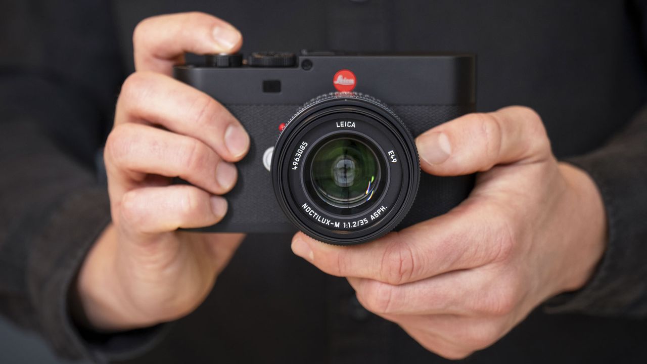 Leica Noctilux-M 35 f/1.2 ASPH lens on a Leica camera, held by photographer