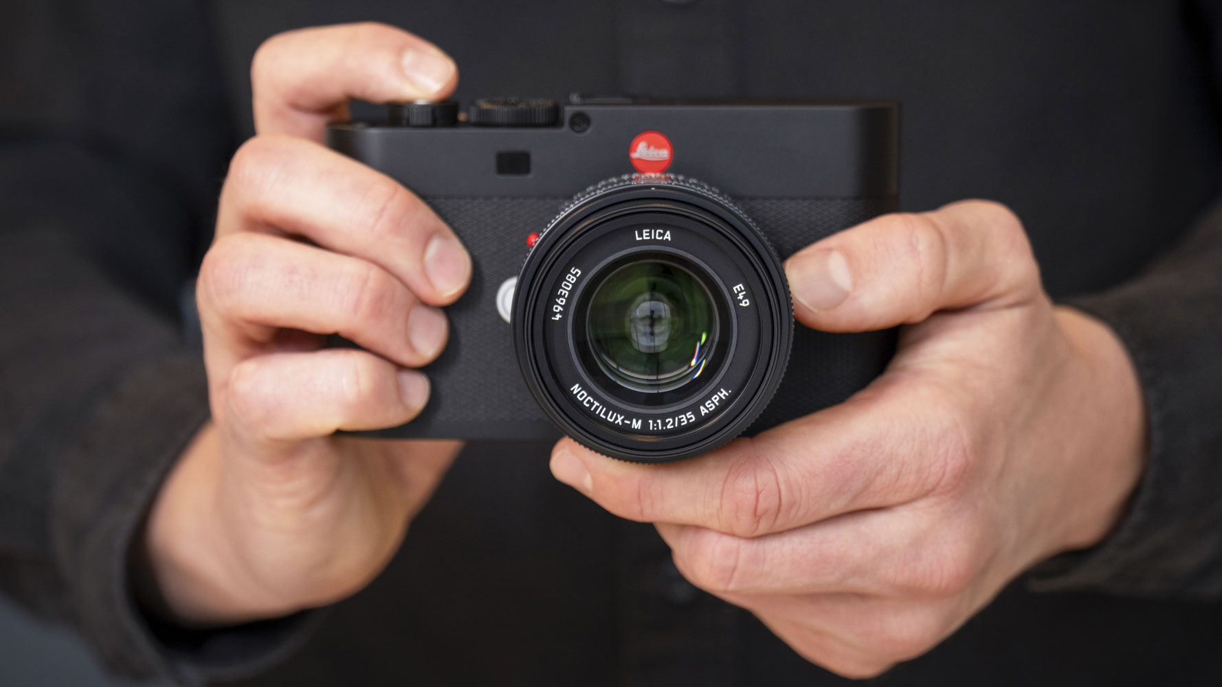 Leica Noctilux-M 35 f/1.2 ASPH lens on a Leica camera, held by photographer